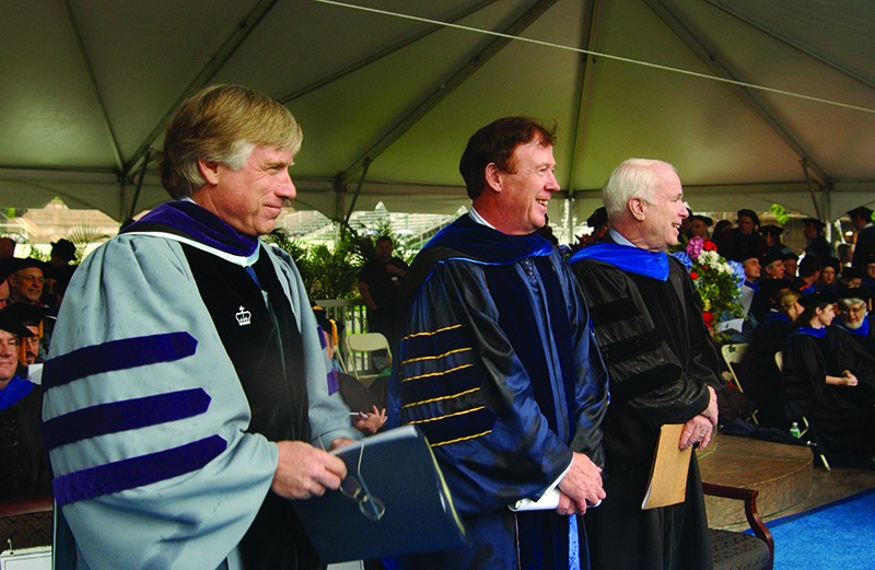 Sen. McCain with University President Lee C. Bollinger (left) and then-Columbia College Dean Austin E. Quigley (center) when McCain spoke at the 2006 Columbia College Class Day ceremony. Three men wearing academic regalia stand beneath a large tent.