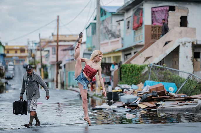Photo by Omar Z. Robles Standing in the middle of a flooded street, a ballerina dressed in blue jean shorts and a bandeau top stands on pointe on her left leg and lifts her right into a 180-degree split.