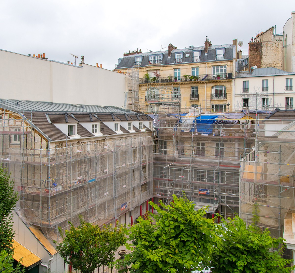 Photograph of the Reid Hall courtyard with the buildings covered by scaffolding