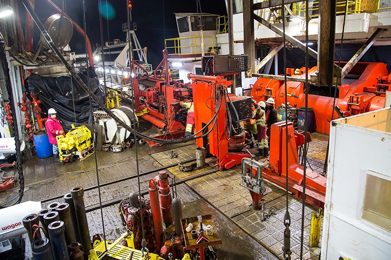 The drill floor on board the RV Joides Resolution. Photo by Gisela Winckler A floor inside the Joides Resolution ship filled with large orange drills and machinery.