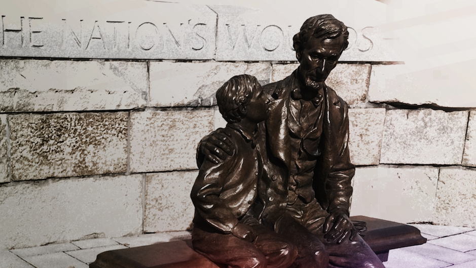 Bronze statues of boy looking at father with sad expressions