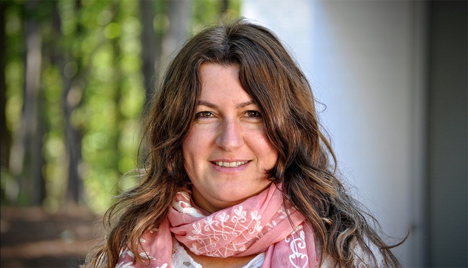 Neslihan Senocak smiling, wearing a pink scarf