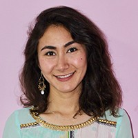 Medium-skinned woman with shoulder-length brown hair, in a light green and pink shirt.