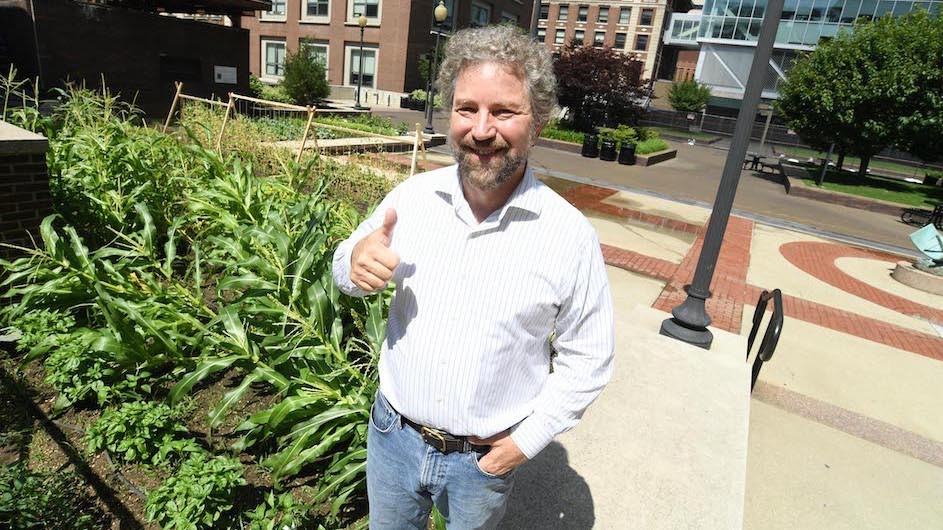 J. Thomas Vaughan giving a thumbs up next to his garden