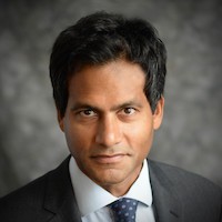 Jameel Jaffer from the Knight Institute: Dark haired man wearing gray suit, white shirt and blue tie with gray dots.