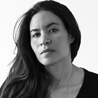 Black and white headshot of Yasmine El Rashidi, a medium-skinned woman with long, dark hair in a black top