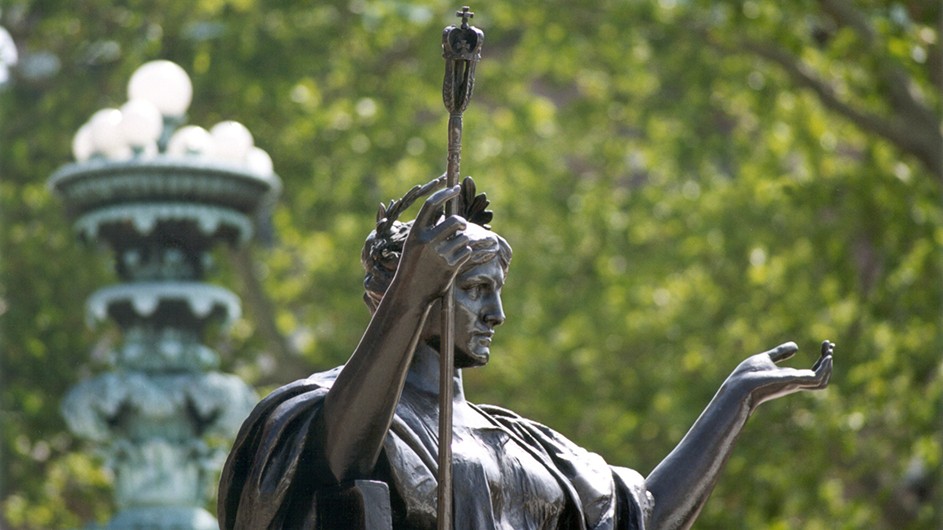 Statue of Alma Mater, a woman with a laurel wreath on her head and a staff, sitting down in the center of Columbia's Morningside campus