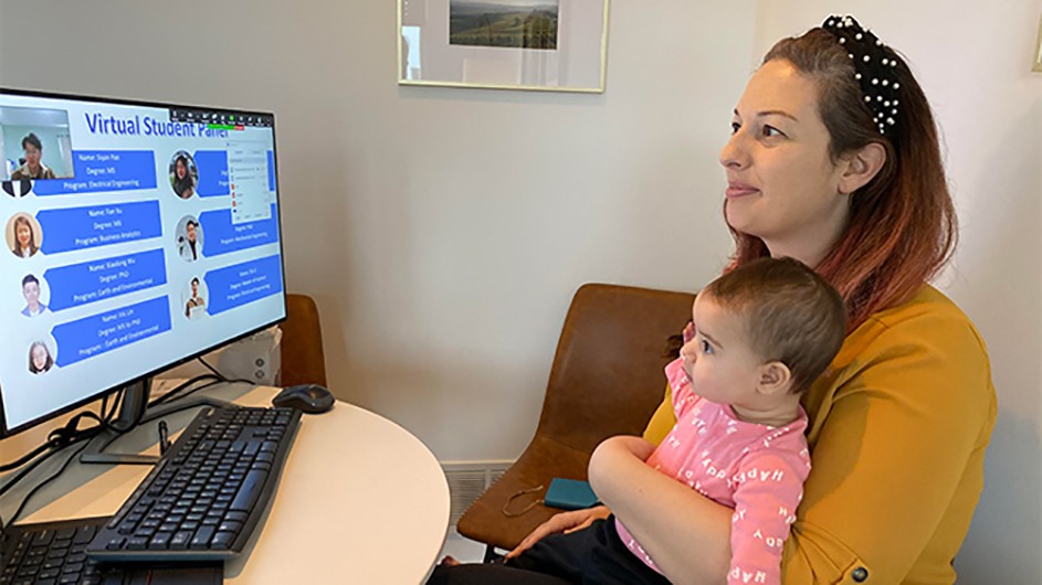 Gabrielle from Engineering and her baby get to work in her home office. A woman and a baby on her lap look at a computer.