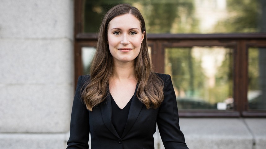 Headshot of Prime Minister Sanna Marin of Finland, a fair-skinned woman with medium brown, long hair, in a black suit