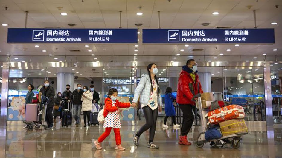 Airport in China with family pushing a luggage and wearing surgical masks
