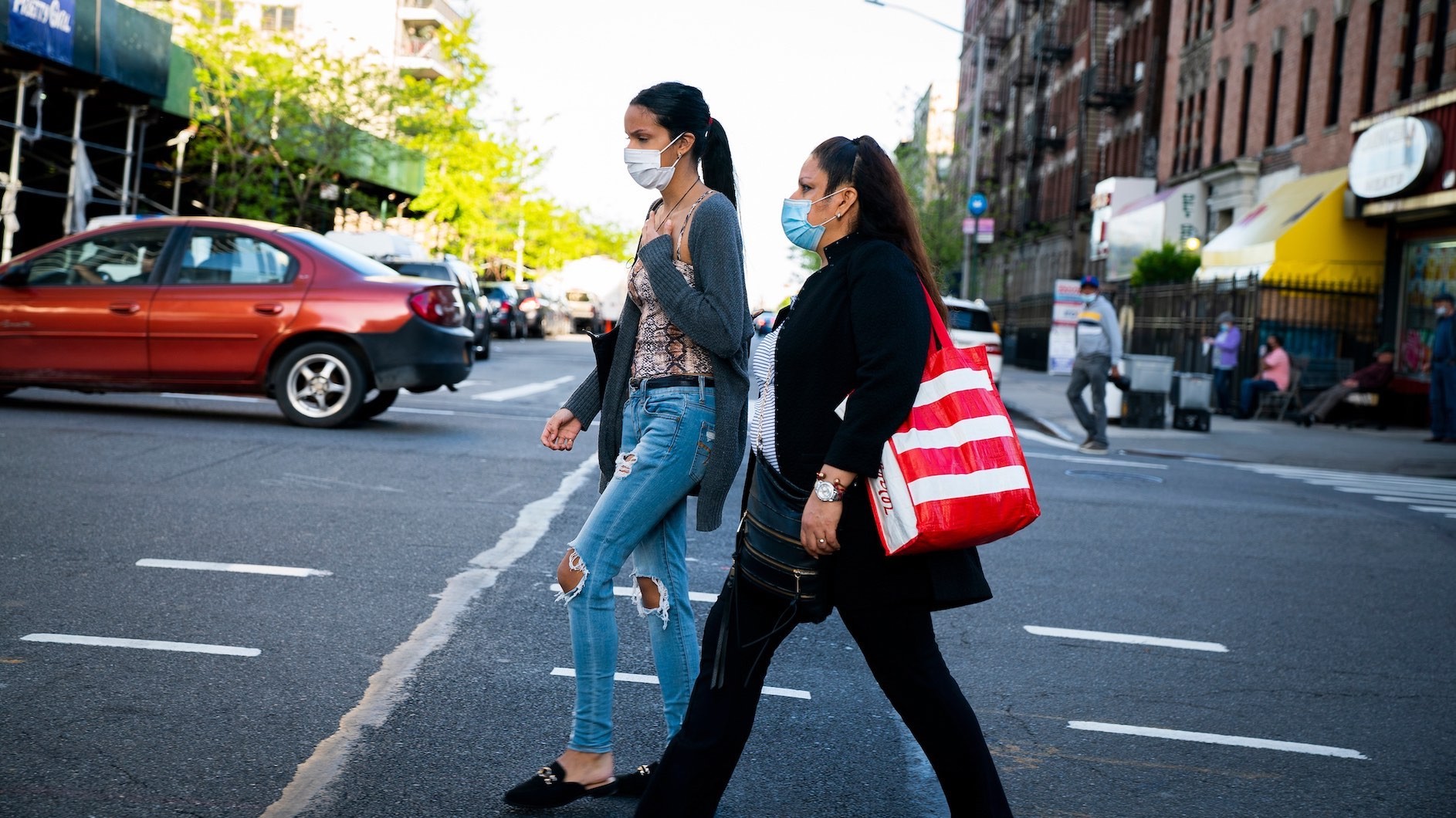 Two women walking in the street in NYC wearing face masks