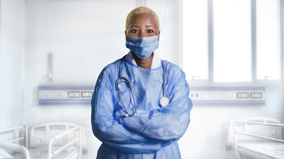 A woman in a face mask and scrubs.