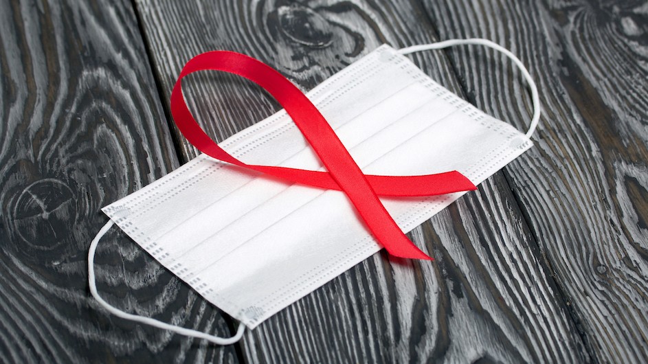 An image of a surgical mask with a red ribbon on top of it