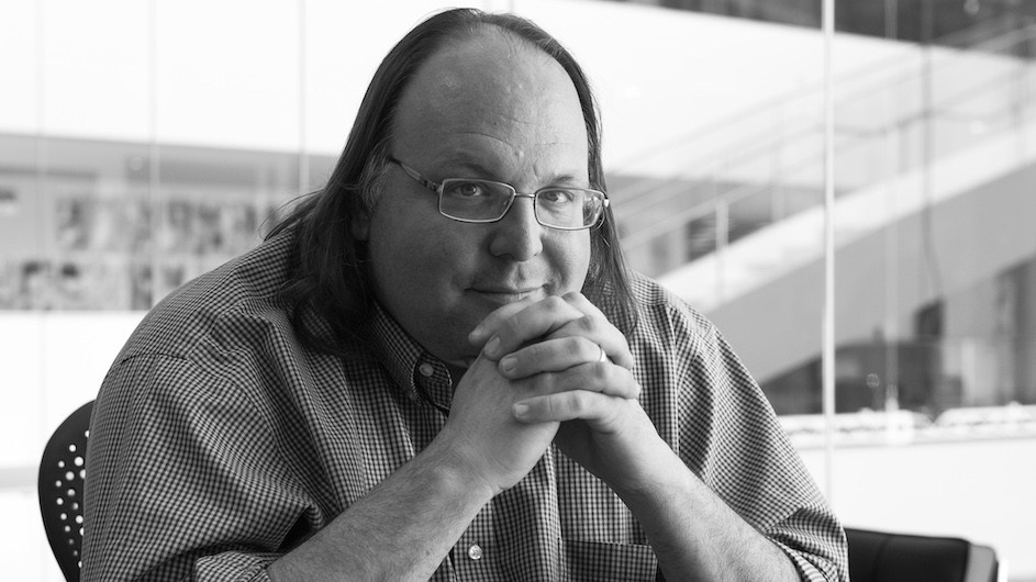 A black and white image of a man with glasses