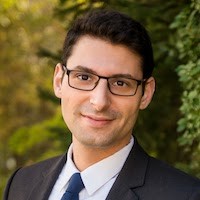 Jesse Schreger: A headshot of a man wearing glasses and a suit