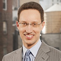 Keith Goggin Man with short hair in a light suit and tie.
