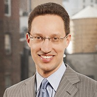 Man with short hair in a light suit and tie. 