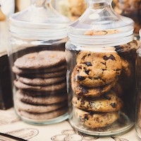 Two clear glass cookie jars filled with cookies