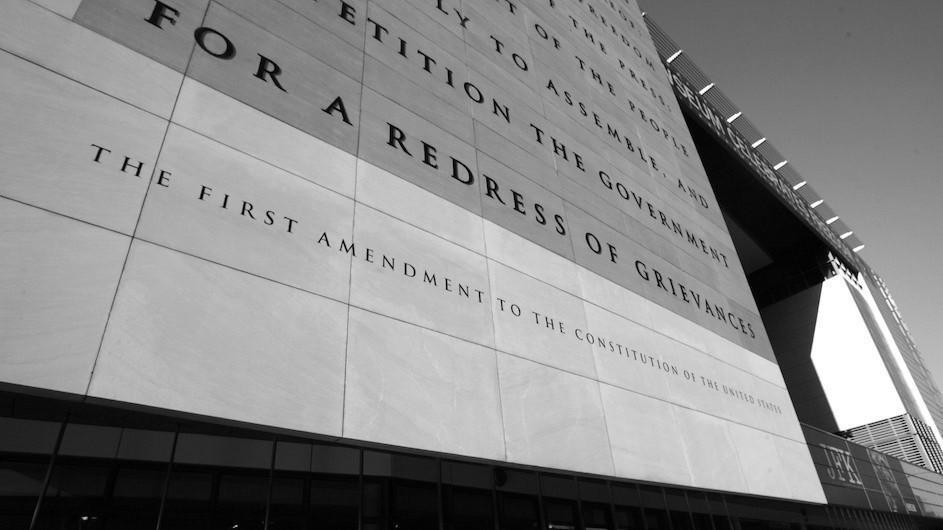 A black and white photo of a side a building with the First Amendment inscribed on it.