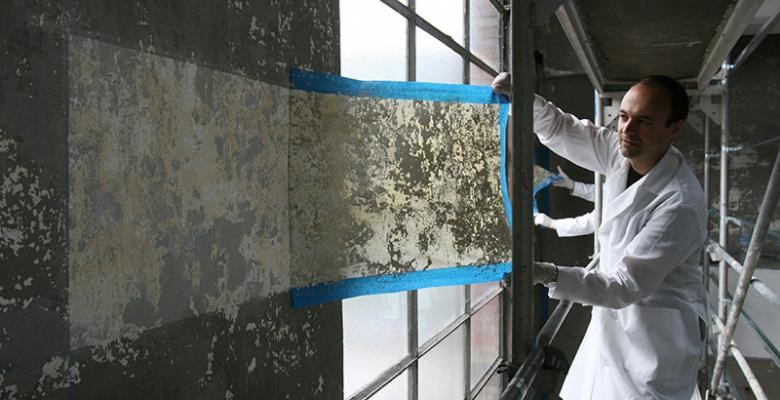 Wearing a white lab coat, Jorge Otero-Pailos carefully cleans the marble wall of the Alumix factory in 2008. Photo Courtesy of Patrick Ciccone