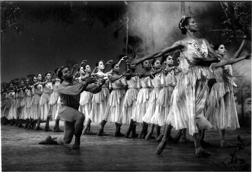 A row of ballet dancers in white dresses