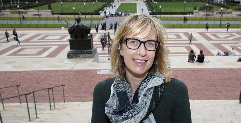 Photo by John Pinderhughes Kate Marvel on the steps of Low Library with Alma Mater behind her.