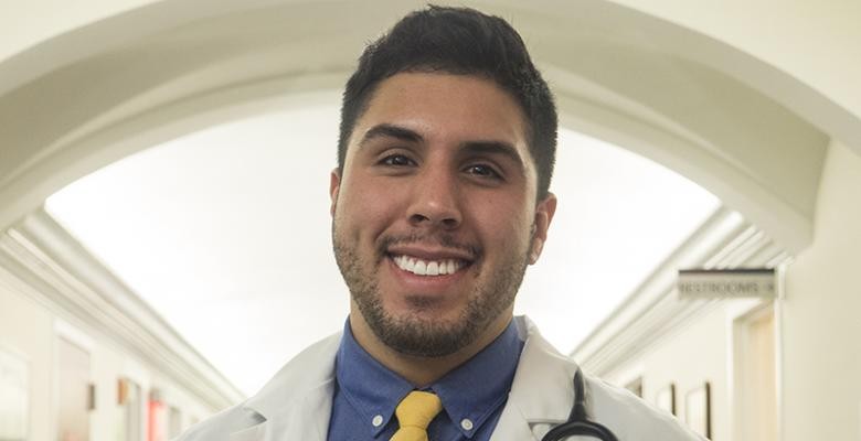 Michael Hernandez smiling while in his lab coat