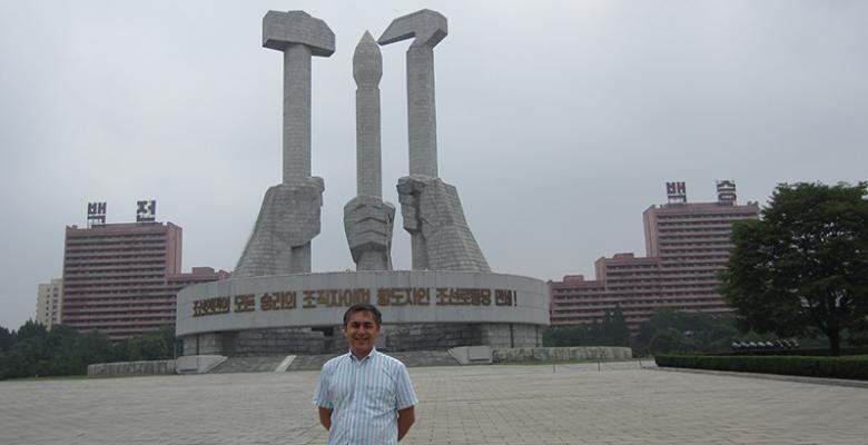 Charles Armstrong stands in front of a statue in North Korea.