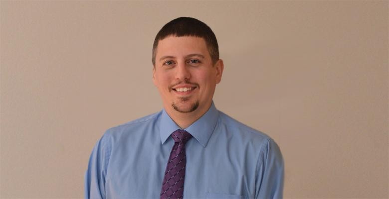 Richard Nephew in a light blue button-down shirt and purple tie