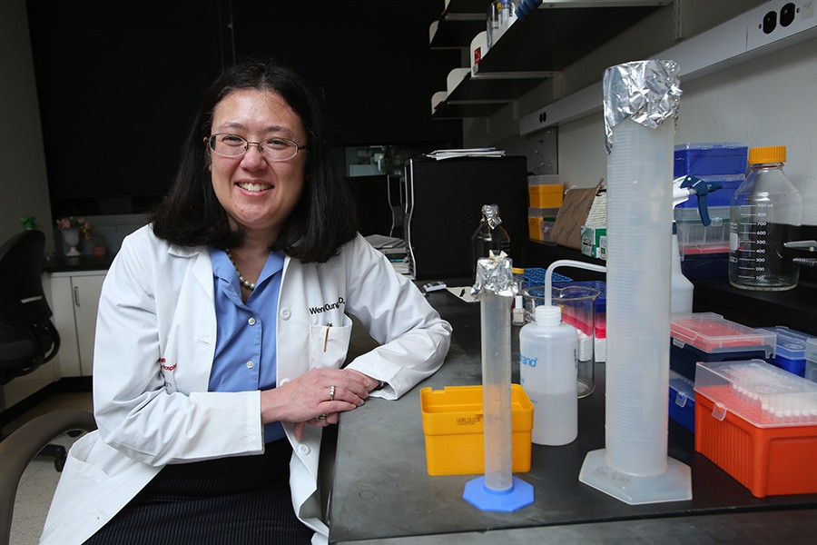 Wendy Chung. Photo by Bruce Gilbert Wendy Chung sitting at her laboratory