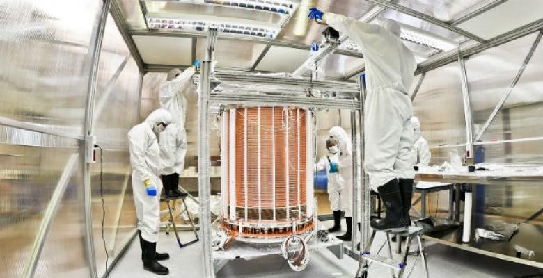 Elena Aprile leads the XENON collaboration, which has built the world’s largest and most sensitive device yet to look for evidence of weakly interacting massive dark matter particles, or WIMPs. (Symmetry magazine) Scientists in white suits work on a device
