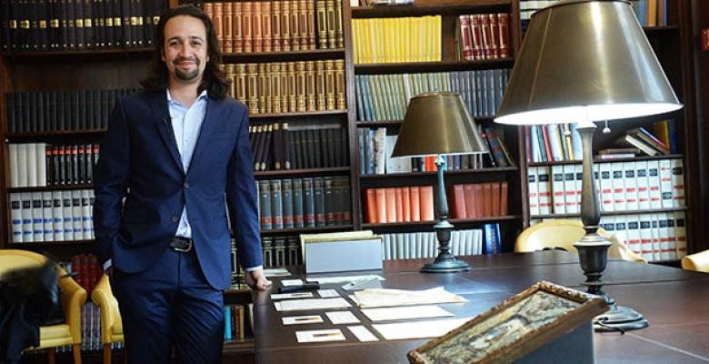 Lin-Manuel Miranda standing in front of desk