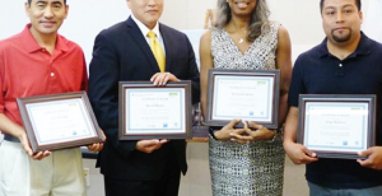 Four graduates with certificates