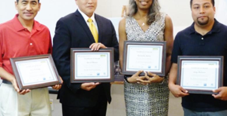 The winners of the Year 1 Case Study Competition, an integral part of the construction mentorship program, hold their awards. From left: Yam Gurung, J&Y Electric and Intercom Company Inc.; David Muñoz (mentor), Skanska USA Building Inc.; Kimberlee Kelley, Artisan Construction; Jorge Barbosa, U. Arias Corp. Four graduates with certificates