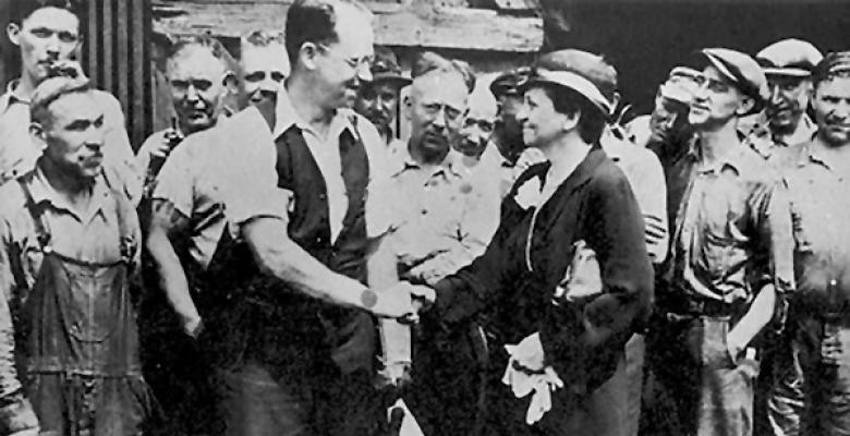 Frances Perkins shakes hands with a man