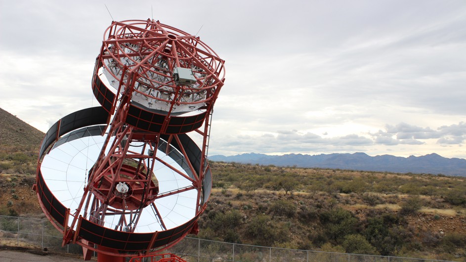 The Schwarzschild-Couder telescope, located at the Fred Lawrence Whipple Observatory in Amado, Arizona, detected gamma-ray showers from the Crab Nebula in early 2020, proving the viability of the technology design for gamma-ray astrophysics. Photo: Amy C. Oliver, Center for Astrophysics | Harvard & Smithsonian sky, hills and cloud background with giant circular mirrored telescope with red cross cross beams