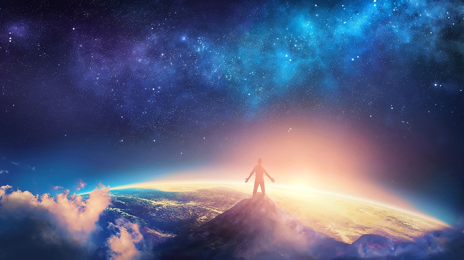 dark blue sky, man stands on top of mound with light beaming ahead