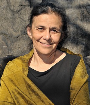 top half of dark haired woman in black shirt and tan shawl