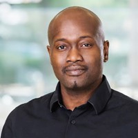 Samory Kpotufe: Head shot of a man with black shirt and green background