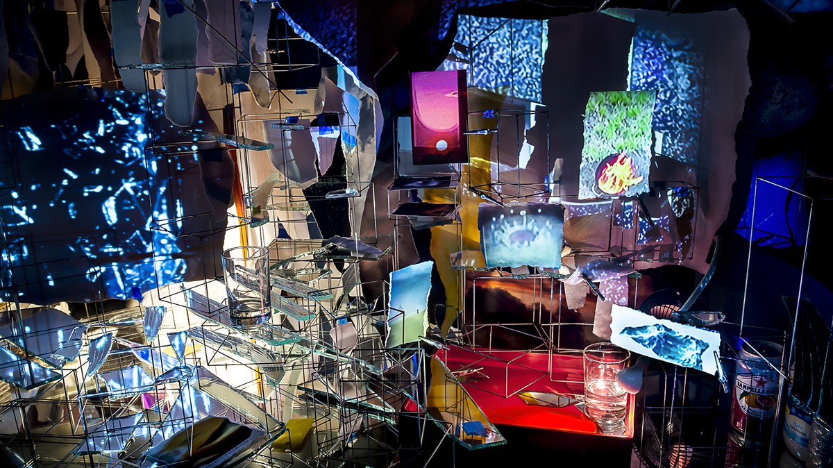 "Timekeeper" (2016), detail, Sarah Sze, mixed media, mirrors, wood, stainless steel, archival prints, projectors, lamps, desks, stools and stone; courtesy of Sarah Sze Studio. An artistic installation made of different sized and shaped and colored things.