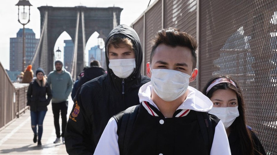 Masked young people crossing a bridge