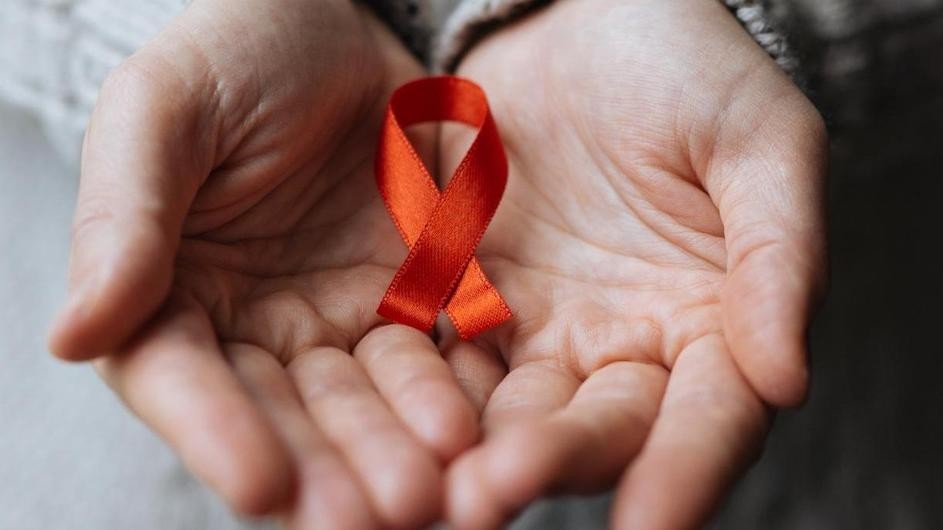 Hands holding a red ribbon.