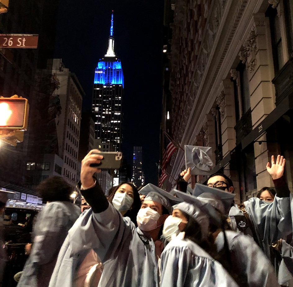 A gaggle of graduates pose near Flatiron with the Empire State Building. 