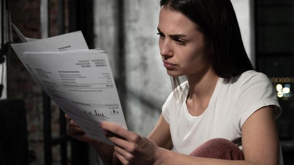 A stock image of a person looking at bills.