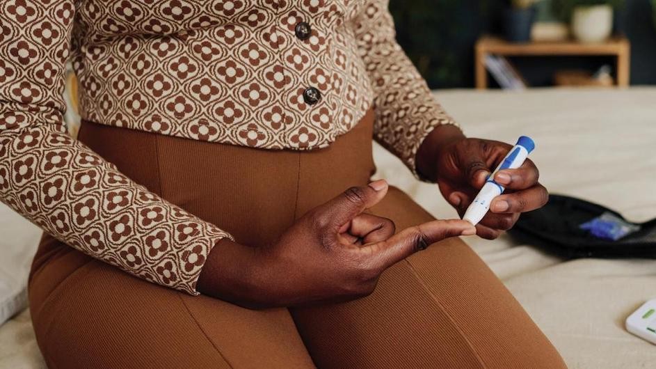 A person pricking their finger to test blood sugar levels.