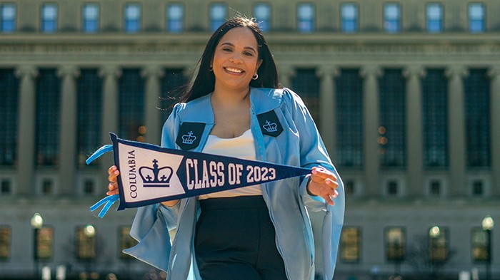 Carla Alba poses with a Class of 2023 pennant in front of Butler Library.