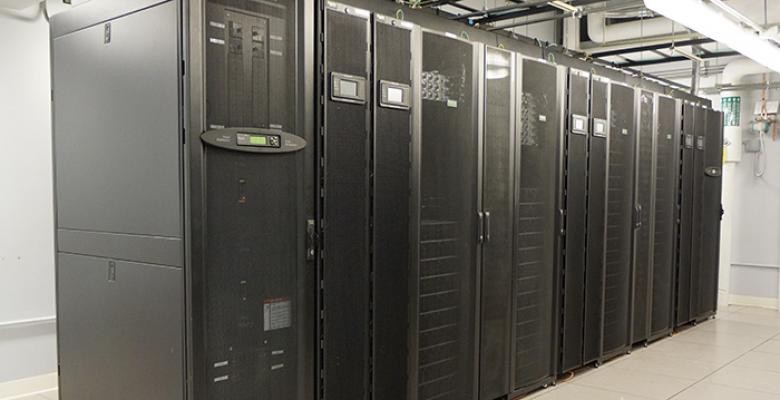 cluster of computers in upright positions placed behind glass doors 