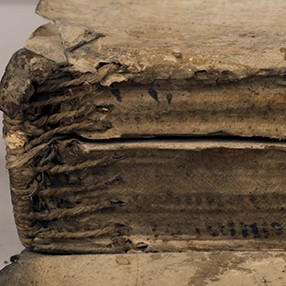 A detail of the sewn binding of an ancient book.