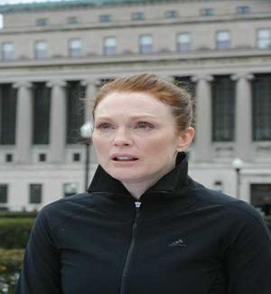 Actress Julianne Moore dressed in black sports jacket while hair is pulled back away from face.