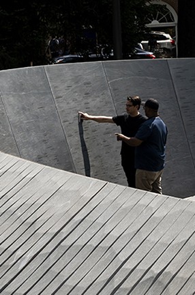 A detail of the "Memory Marks" at the Memorial to Enslaved Laborers; photo by Sanjay Suchak, University of Virginia Communications. Two men look at a stone sculptured wall of the "Memory Marks" at the Memorial to Enslaved Laborers in Charlottesville, Va.